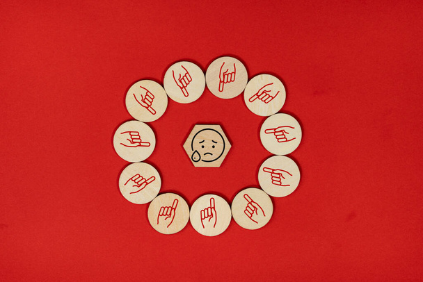 Diseño de baldosas de madera con emoji grito rodeado de emoji mano que apunta. Concepto de ciberacoso - Foto, imagen