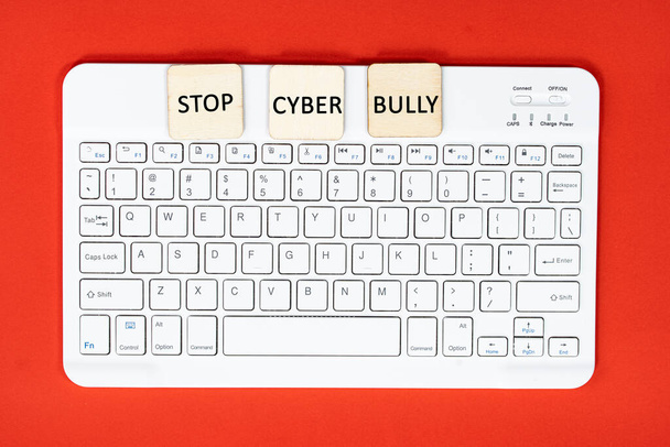 Layout di tastiera e piastrelle in legno con testi STOP CYBER BULLY. Concetto di cyberbullismo - Foto, immagini