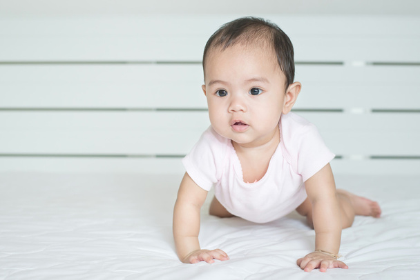 アジアのかわいい女の子の赤ちゃんの寝室でクロール - 写真・画像