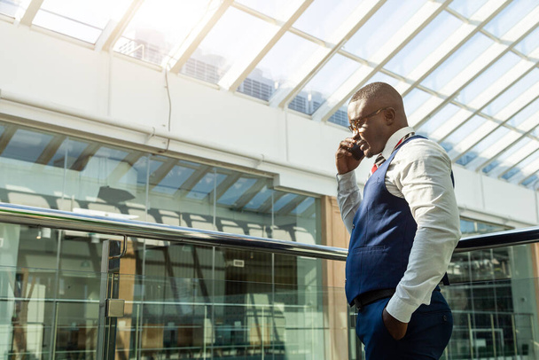 Portrait of a businessman in suit are standing on the background of glass offices. - 写真・画像