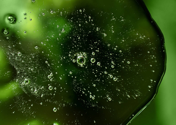Spalmatura liquida, campione di cosmetici sullo sfondo verde.Vista dall'alto, superficie liquida antibatterica.. - Foto, immagini