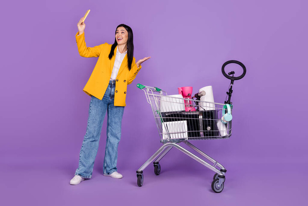 Full length photo of young blogger lady donate old things wear jeans blazer isolated on violet color background. - 写真・画像