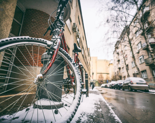 Kerékpár a hóban egy téli utcában egy európai városban, környezetbarát közlekedési és kerékpárszerkezet - Fotó, kép