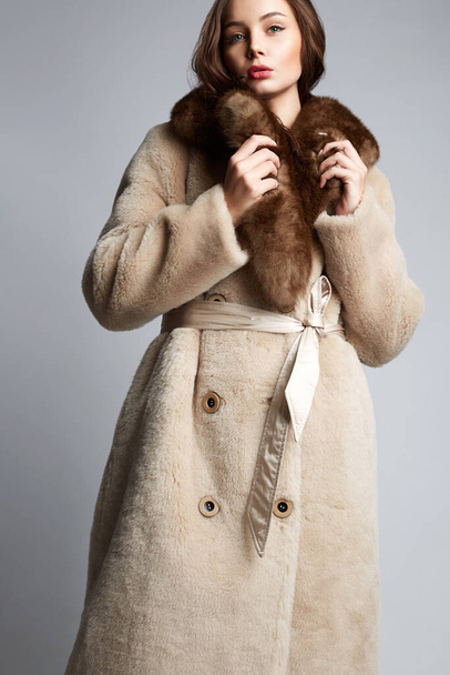 Piękna młoda kobieta w futrze. piękna dziewczyna w modnej zimie płaszcz mody - Zdjęcie, obraz