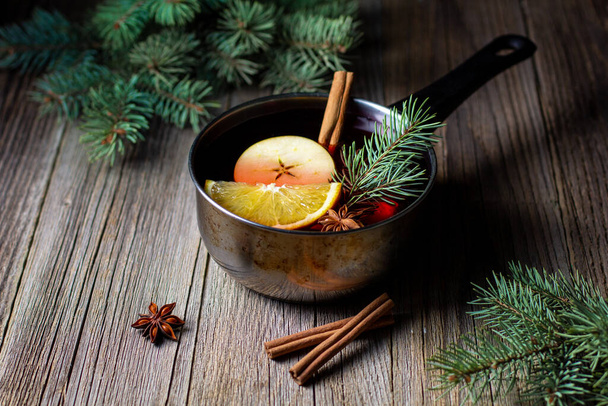 Leckerer Glühwein mit Mandarinen-Orangen-Apfelgewürzen und Weihnachtsbaum im Topf. Herbstliches Heißgetränk - Foto, Bild