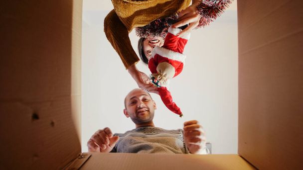POV of man and woman opening box with garlands and ornaments - Photo, Image