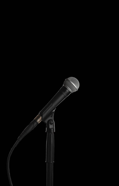 Dynamisches Gesangsmikrofon auf einem Stativ mit schwarzem Hintergrund - Foto, Bild