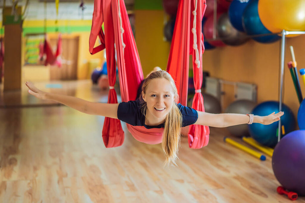 Young beautiful woman practicing aerial yoga in gym. Lifestyle - Фото, зображення