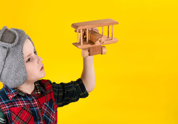 子供はおもちゃの木製のヴィンテージ飛行機で遊ぶ. - 写真・画像