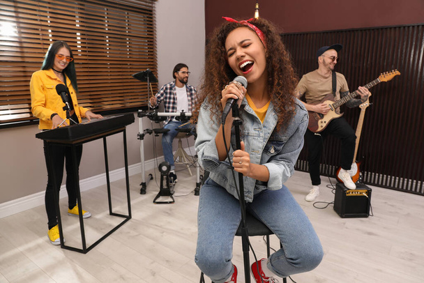 Music band performing in modern recording studio - Photo, image