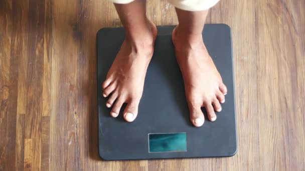  young mans feet on weight scale top view  - Footage, Video