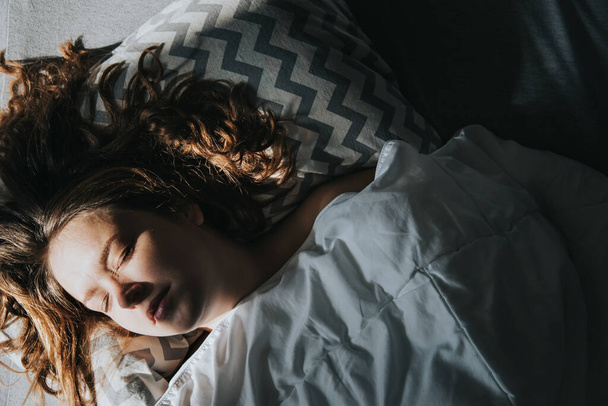 Portrait of a sleeping caucasian woman in the morning sun. - Фото, изображение