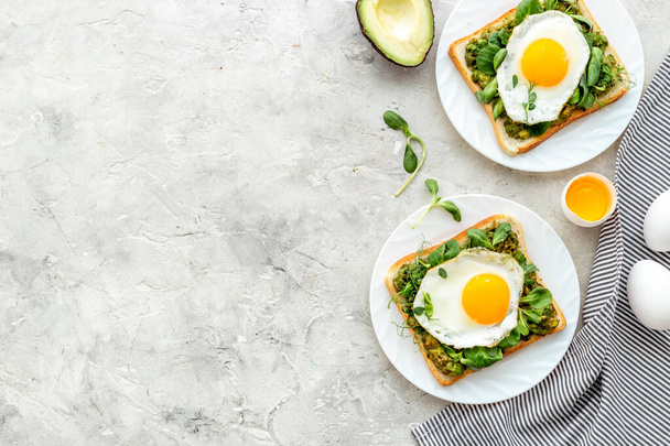 Open sandwich with avocado spinach cream and eggs. Top view - Photo, Image