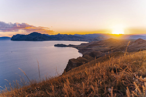 Upea vuoristo maisema auringonlaskun säteet meren rannikolla ja vuoret Krimillä. Panoraamanäkymät Koktebelille ja Cape Chameleonille - Valokuva, kuva