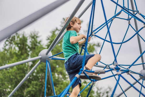Young boy on climbing rope in playground - Zdjęcie, obraz