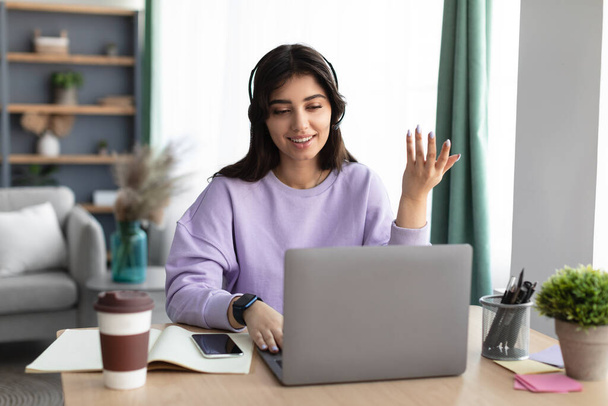 Mujer en auriculares con videocall usando laptop, hablando y haciendo gestos - Foto, Imagen
