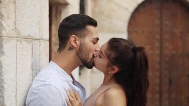 Onnellinen etninen pari koskettaa nenää puhuessaan kaupungissa - Materiaali, video