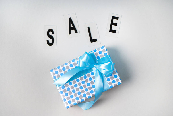 Gift box with a bright bow and the inscription SALE - Photo, image
