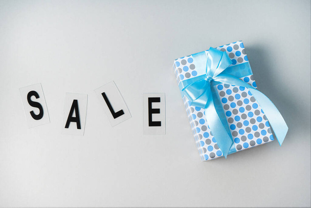 Gift on a gray background in a blue package. Black Friday concept for Boxing Day. - Photo, image