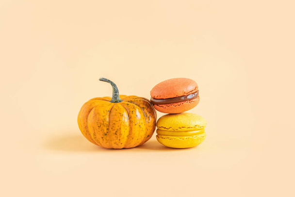 Tasty french macarons with pampkin on a yellow pastel background. Place for text. - Photo, Image