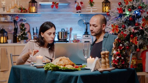 Casal olhando para laptop e comer refeição festiva - Foto, Imagem