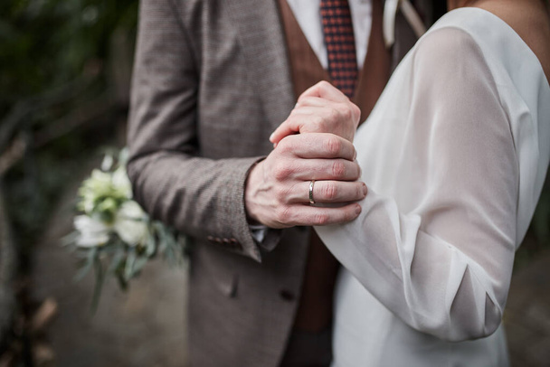 Mariée et marié tenant la main à l'extérieur, thème de mariage - Photo, image