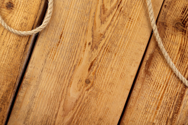 Яркая веревка на фоне деревянных досок с узлами - Фото, изображение