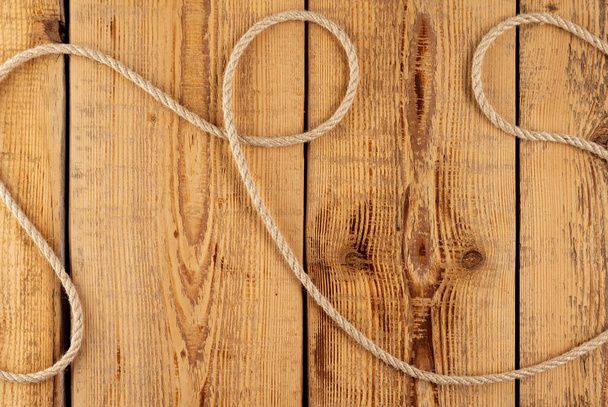 Cuerda brillante sobre un fondo de tablas de madera con nudos - Foto, imagen