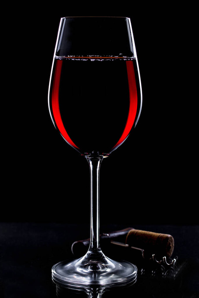 Вино в стакане на черном фоне - Фото, изображение