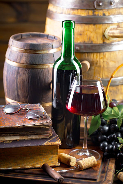 Wine glass with bottle and grapes on an old background. - Foto, imagen