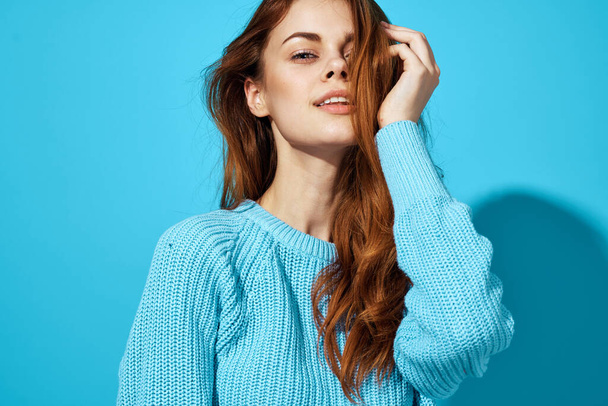 mooie vrouw in een blauwe trui geïsoleerde achtergrond - Foto, afbeelding