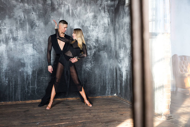 Couple of two professional ballroom dancers is dancing on loft studio. Beautiful art performance. Sport life concept. Passion and emotional dance. - Photo, Image