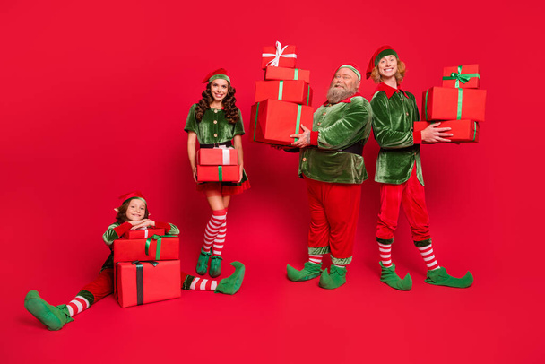 Full size photo of santa service people different age hold giftboxes wear new year costumes isolated on red background - Fotó, kép