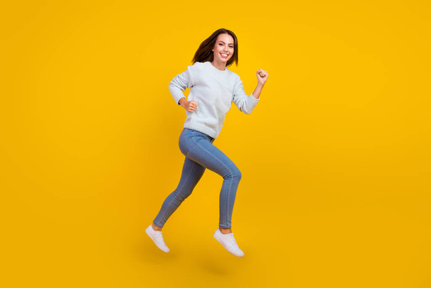 Full size photo of cheerful happy young woman jump up run sale good mood isolated on yellow color background - Foto, afbeelding