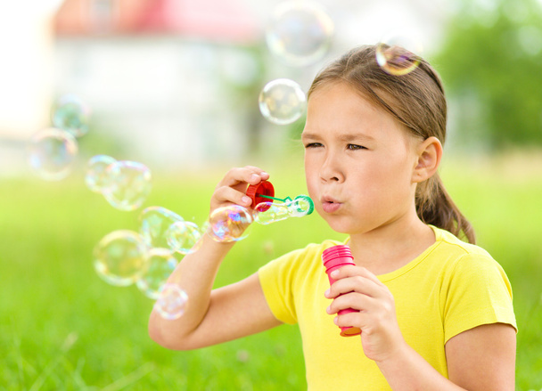 Kleines Mädchen bläst Seifenblasen - Foto, Bild