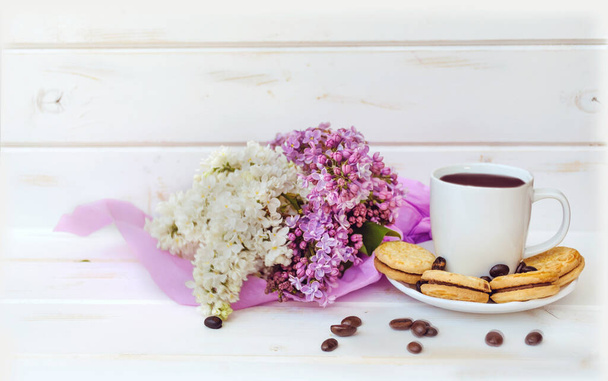 Bouquet of Purple and White Lilac with Cup of Coffee and Biscuits on  Wooden Background  - Photo, Image