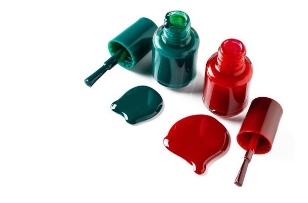Nail polishes spilled out of bottles on white background - Foto, immagini