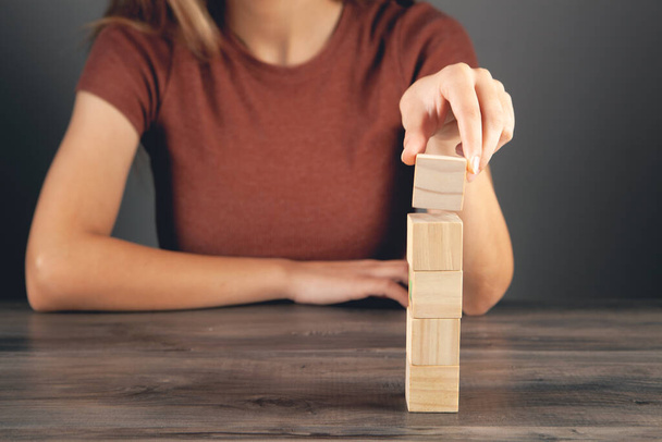 woman holding a tower of wooden cubes - Foto, immagini