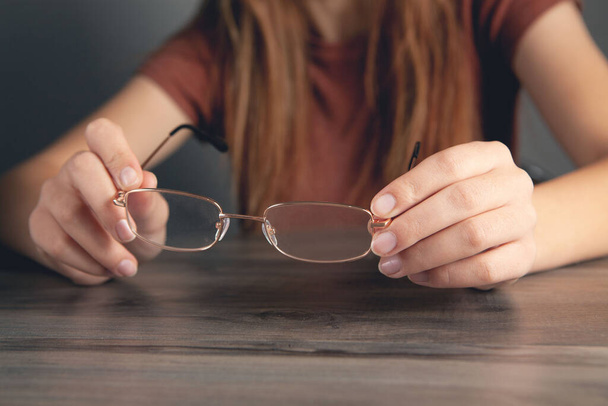 woman holding optical glasses in hand - Фото, зображення