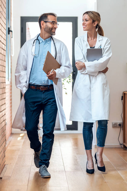 Shot of confident female and male doctors talking about medical information while walking through in medical consultation. - Fotografie, Obrázek