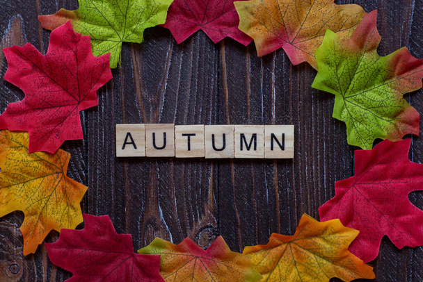 flatley, autumn maple foliage, autumn inscription in wooden letters on the table. Autumn mood theme. - Photo, Image
