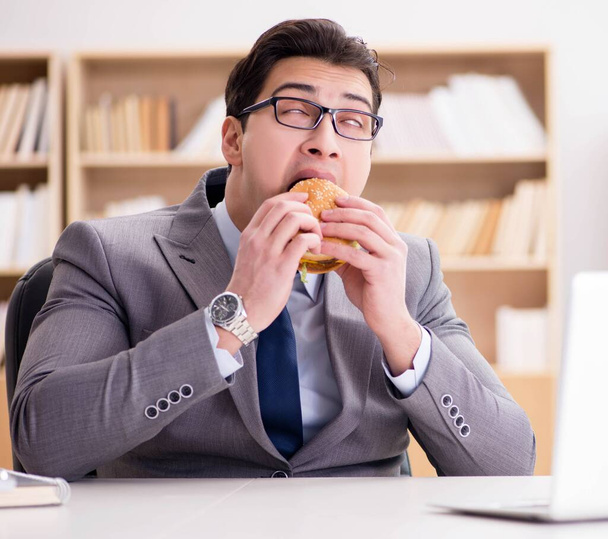 Голодные веселые бизнесмены едят сэндвичи с нездоровой едой - Фото, изображение