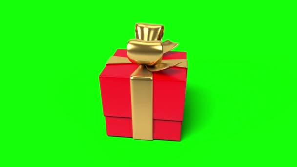 Spinning rode glanzende geschenkdoos met een gouden strik op een groene achtergrond. Feestelijke achtergrond. - Video