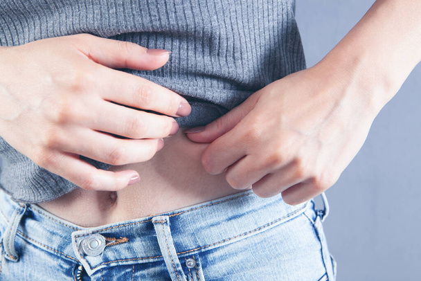 young woman checks belly fat - Foto, Bild
