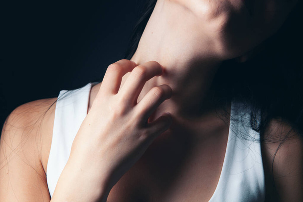 young woman scratching her neck - Valokuva, kuva