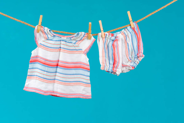 Wäscheleine mit feststeckender Babykleidung aus nächster Nähe - Foto, Bild