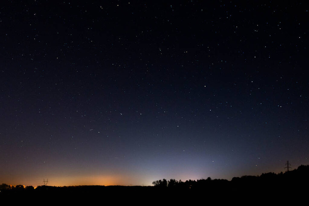 Gece, karanlık gökyüzü yıldız ışığıyla aydınlandı. Birçok yıldız arasında, büyük savaş arabası adı verilen takımyıldızı görebilirsiniz.. - Fotoğraf, Görsel