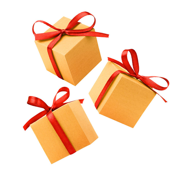 tři zlaté dárkové krabice s červeným lukem na izolovaném bílém pozadí - Fotografie, Obrázek