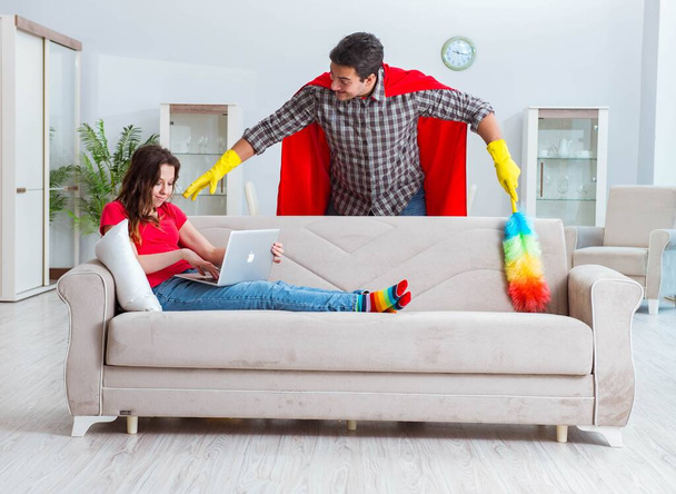 Supersankari aviomies auttaa vaimoaan kotona - Valokuva, kuva