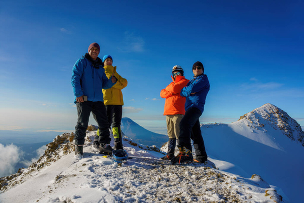 Gruppe von Wanderern, Touristen oder Freunden steht oben auf dem Berg und macht ein Foto - Foto, Bild